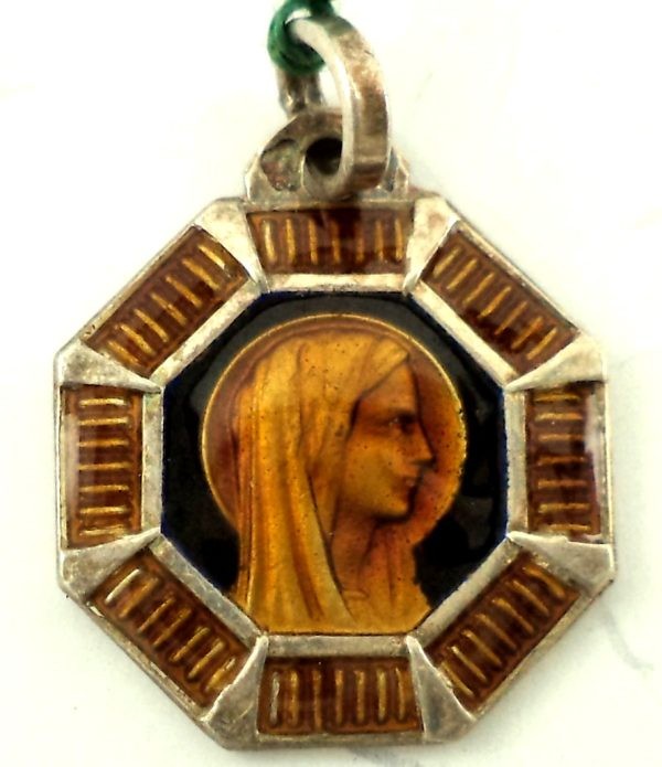 Silver art deco medal with a portrait of the Holy Virgin Mary surrounded by orange and brown enamel design