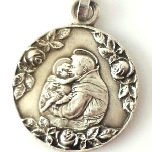 Vintage silver-plated pendant depicting Saint Anthony of Padua with the Infant Jesus surrounded by roses.