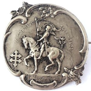 Antique Art Nouveau brooch featuring Saint Joan of Arc in silver-plated finish, front view.