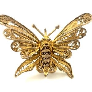 Antique butterfly brooch crafted in gilded filigree, showcasing intricate craftsmanship and a delicate butterfly design.